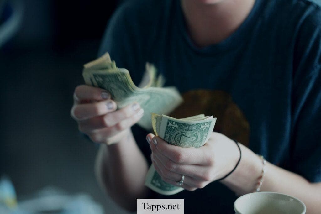 focus photography of person counting dollar banknotes