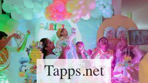 People celebrating baby's birthday with balloons and cakes.